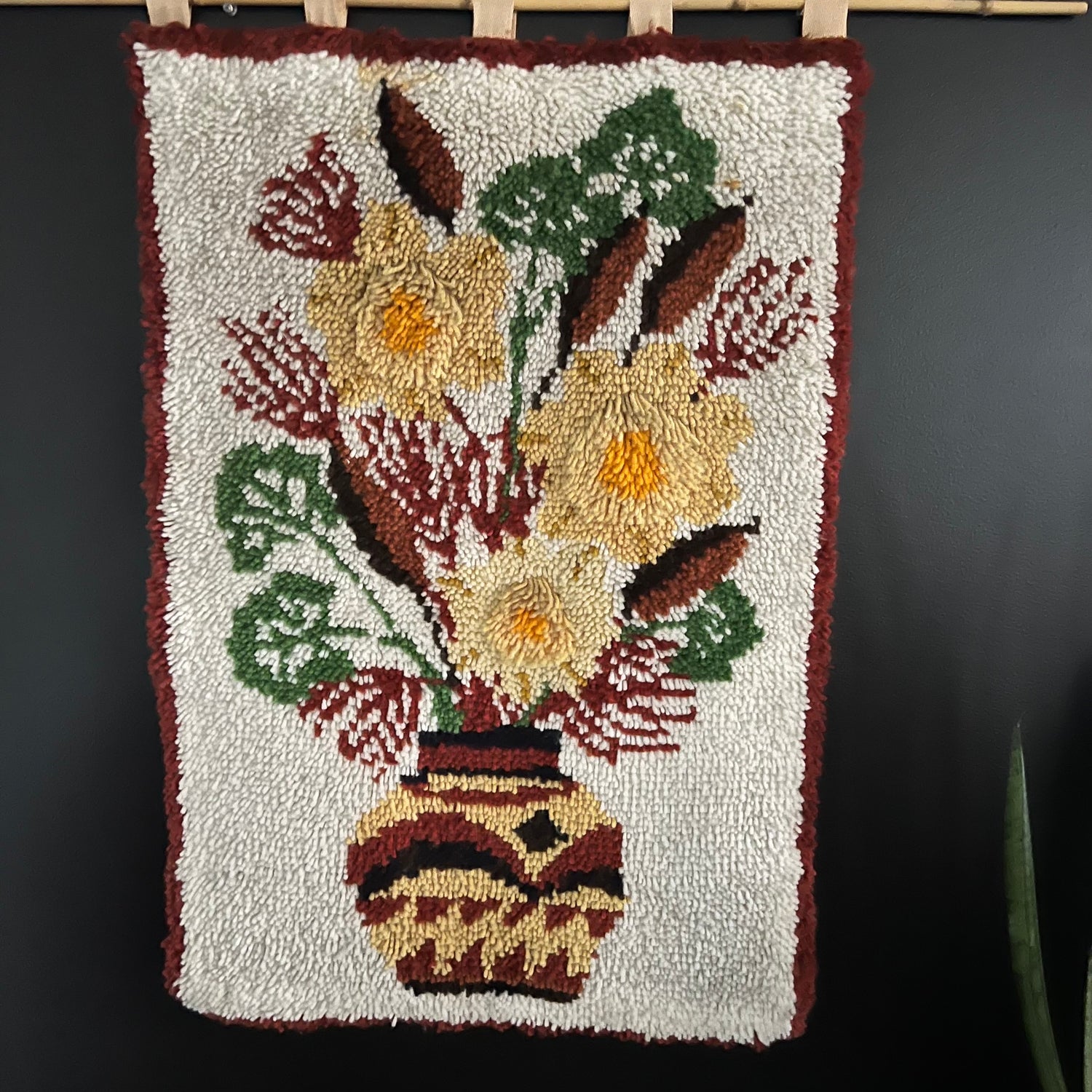 hooked rug with yellow flowers in a brown and yellow vase.